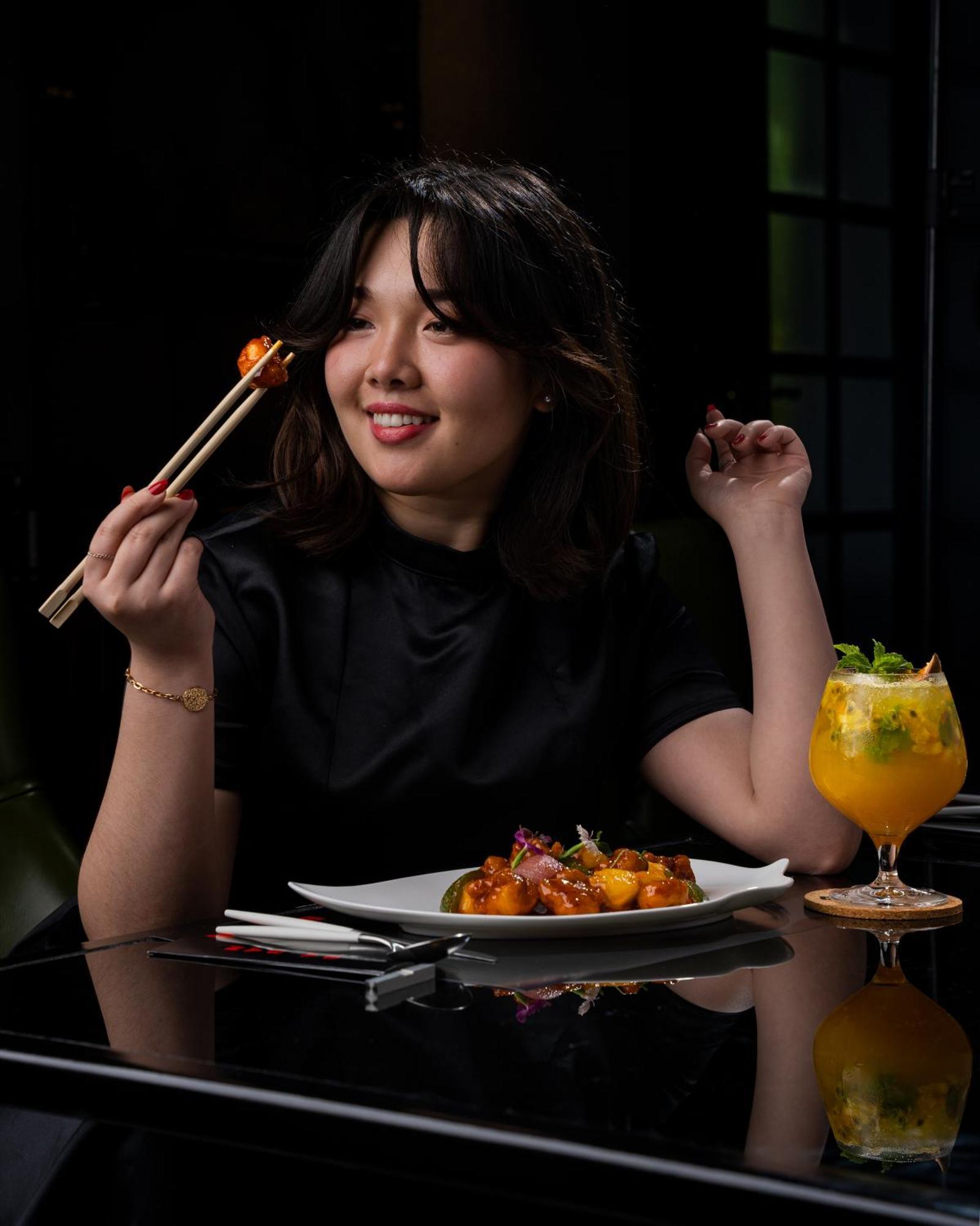 Готель W Маскат Екстер'єр фото A woman eating with chopsticks